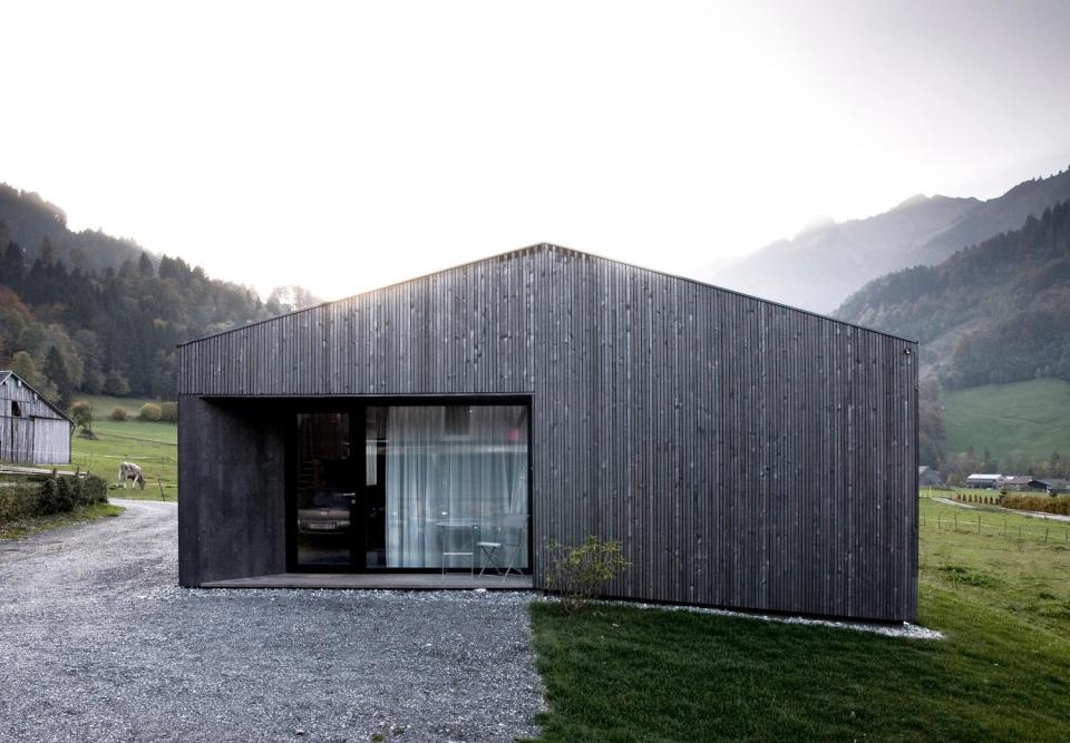 Nowoczesna wersja drewnianej, alpejskiej chaty, z łagodnym dwuspadowym dachem