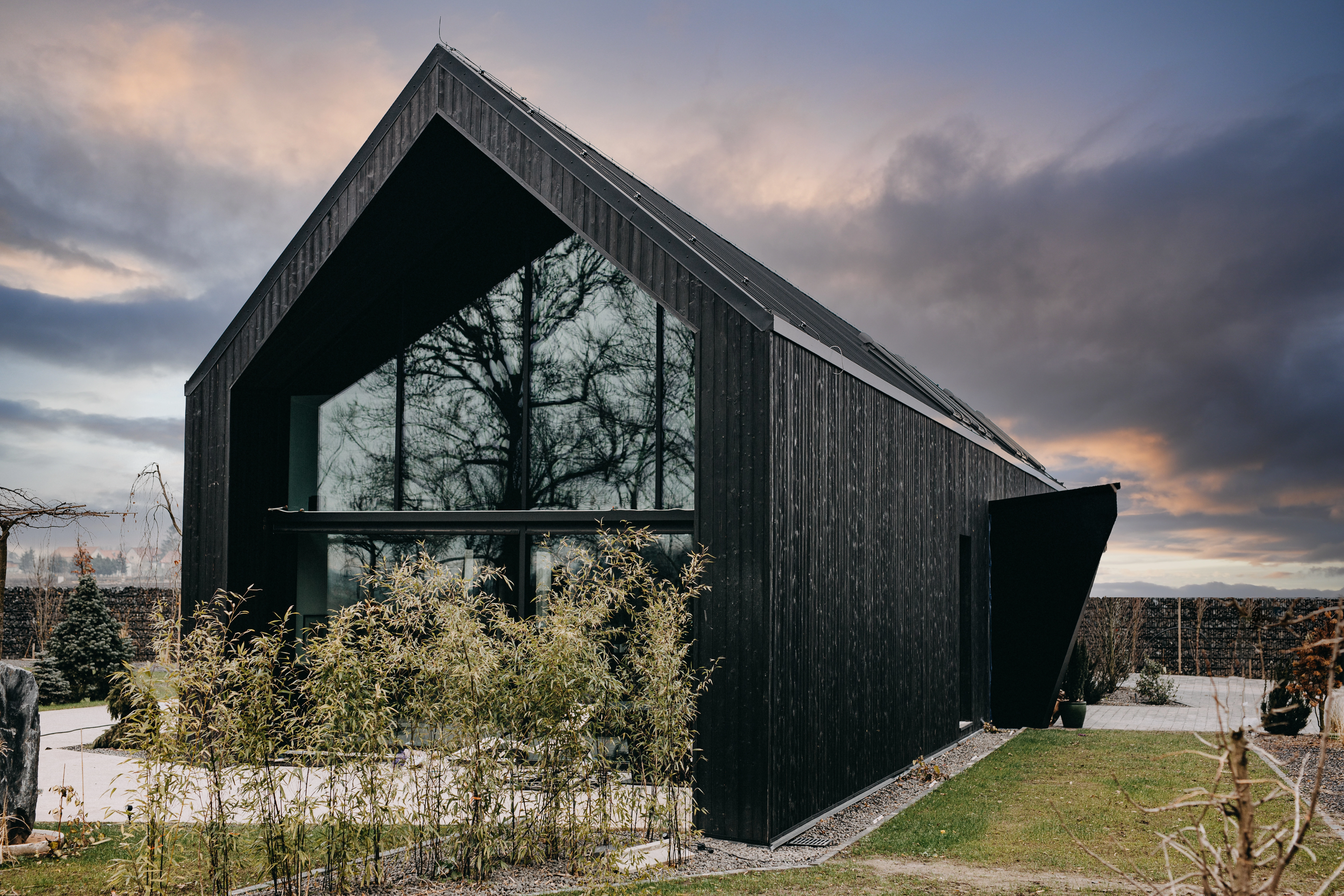 Czarna i minimalistyczna forma domu, podkreśla naturalne walory drewna