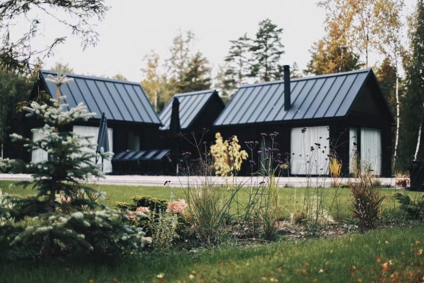 Trzy czarne prefabrykowane domki by MyCabin in Łotwa